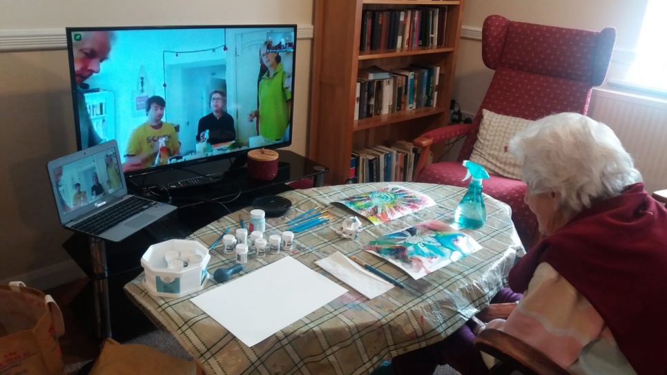 elderly lady on a video call going through a art workshop