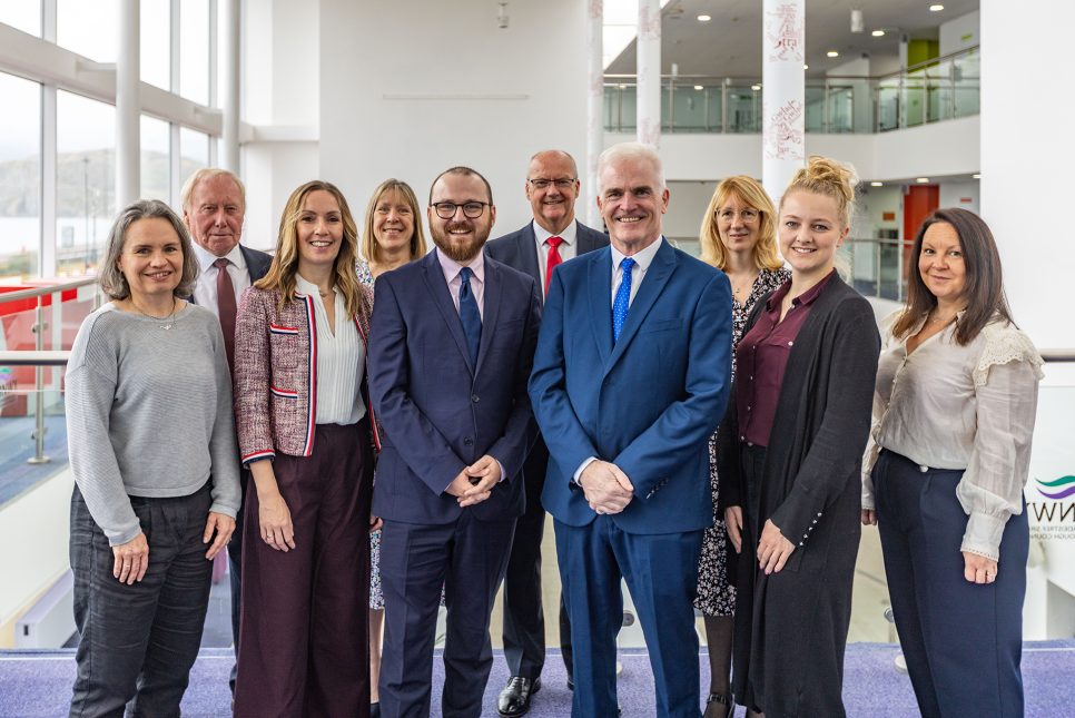 Grŵp o bobl yn sefyll yn atriwm canolog Venue Cymru